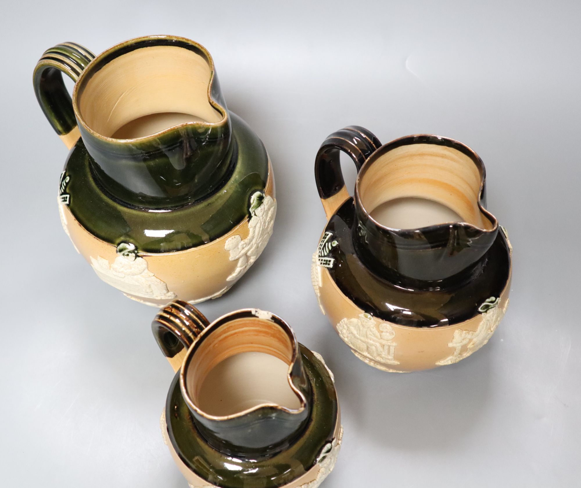 A graduated set of three Victorian Royal Doulton earthenware harvest jugs, tallest 19cm